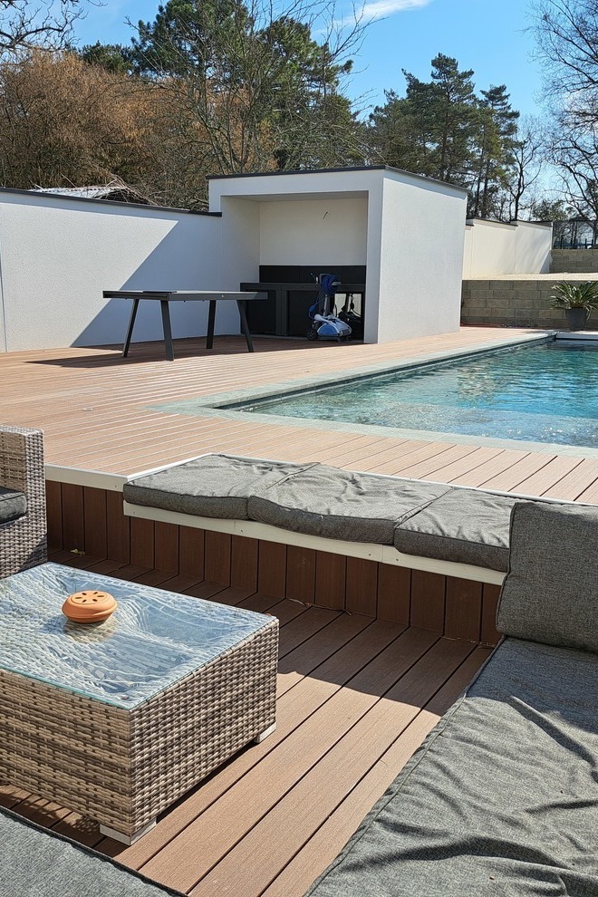 Silvadec composite wood decking around a pool with garden furniture, high-end outdoor layout