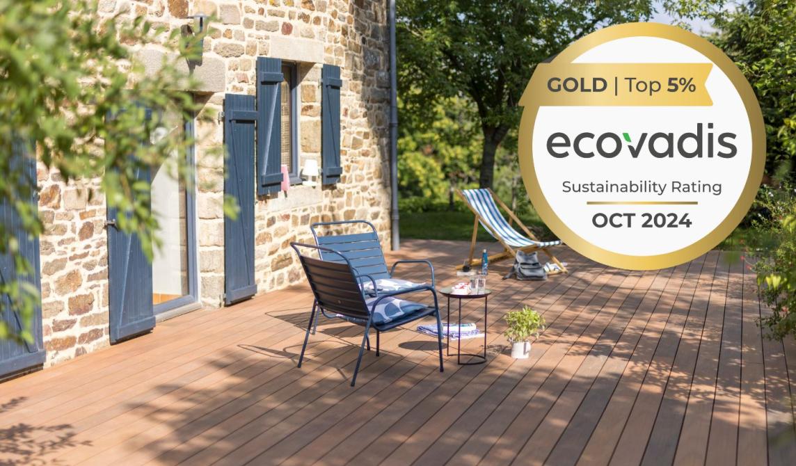 EcoVadis Gold Medal 2024 and Silvadec composite decking in ipe shades with garden furniture in front of a stone house